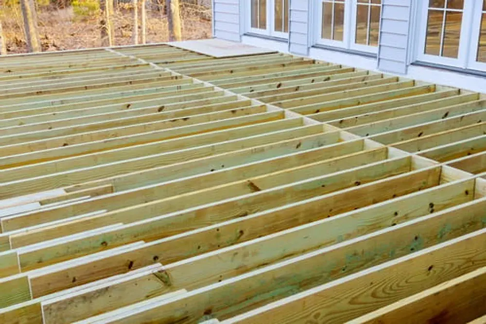 New pressure-treated deck framing and joists installed at a home