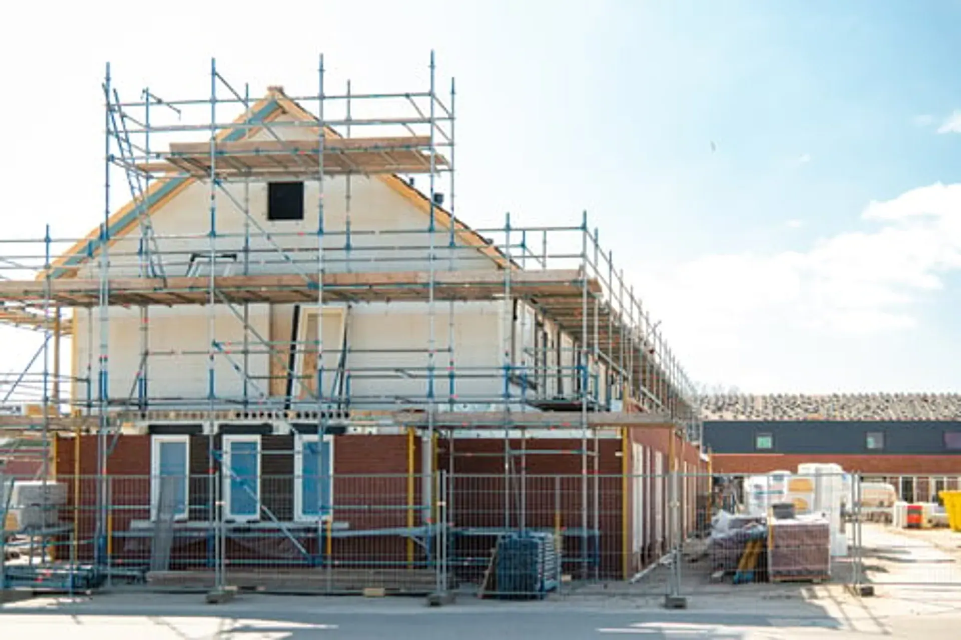 Home under construction with scaffolding during an exterior build