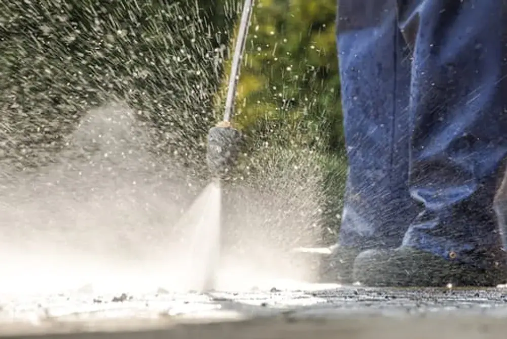 Pressure washer spraying and cleaning an exterior surface